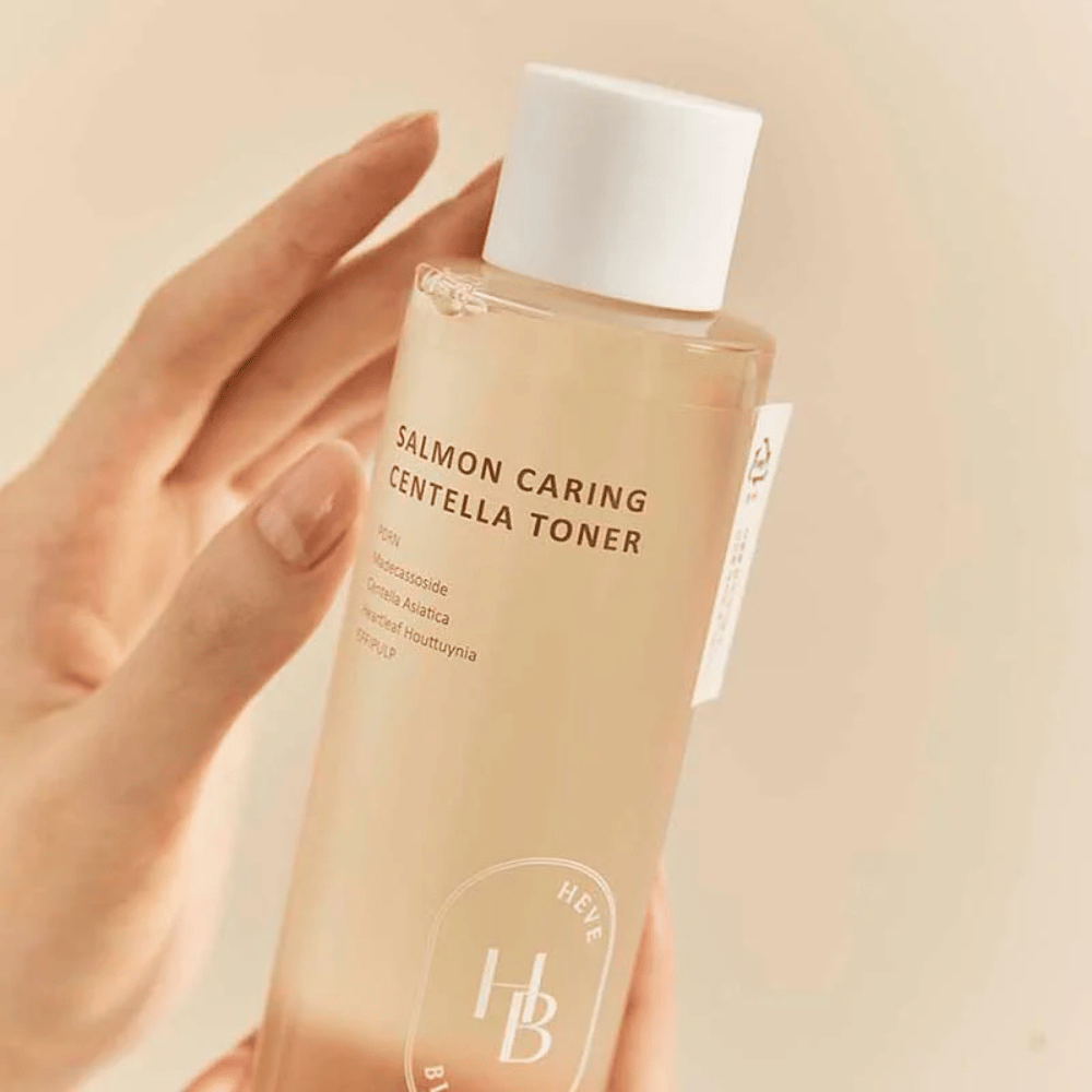 Närbild av Salmon Caring Centella Toner i hand – lugnande toner med PDRN och växtextrakt som hjälper till att stärka huden och minska känslan av irritation.