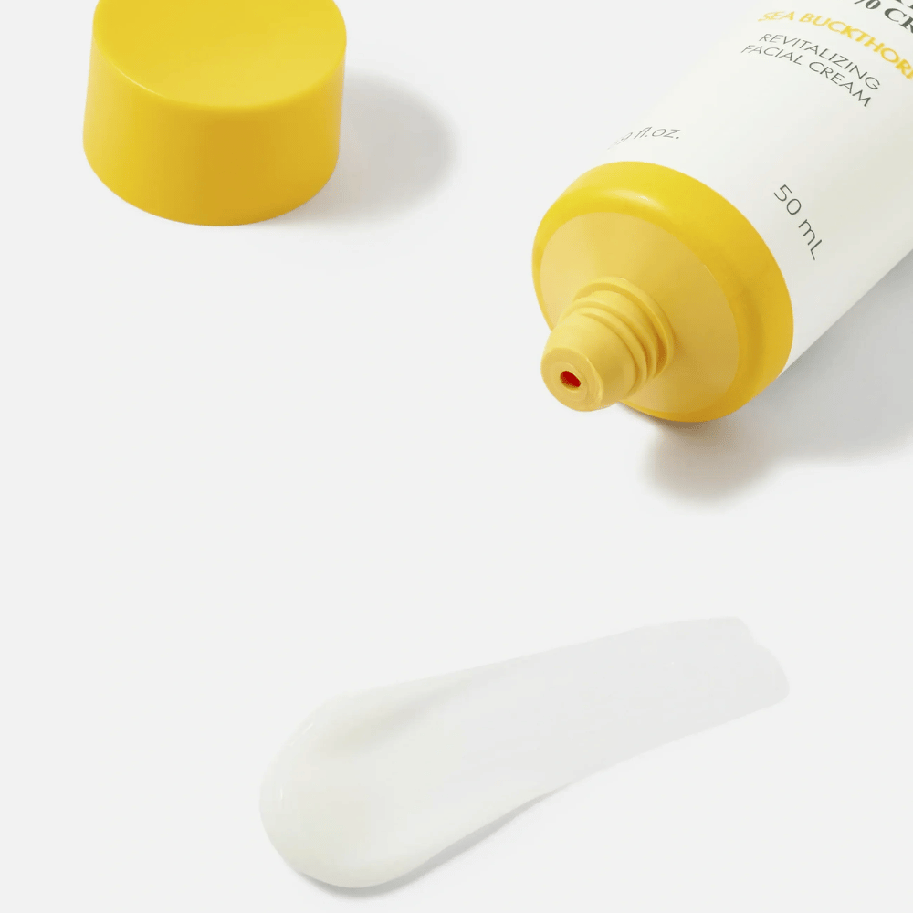 1. Purito SEOUL Sea Buckthorn Vital 70 Cream – närbild på ansiktskrämens lätta vita konsistens bredvid öppen tub med gul kork