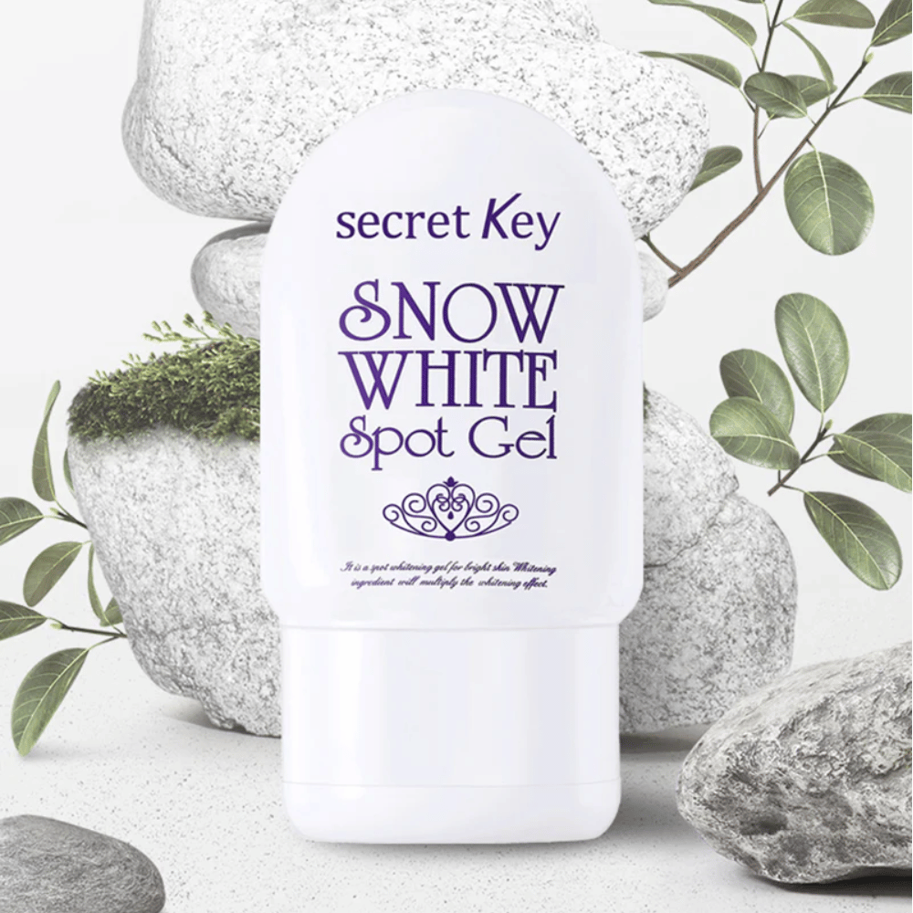 Secret Key Snow White Spot Gel fotograferad mot stenar och gröna blad.