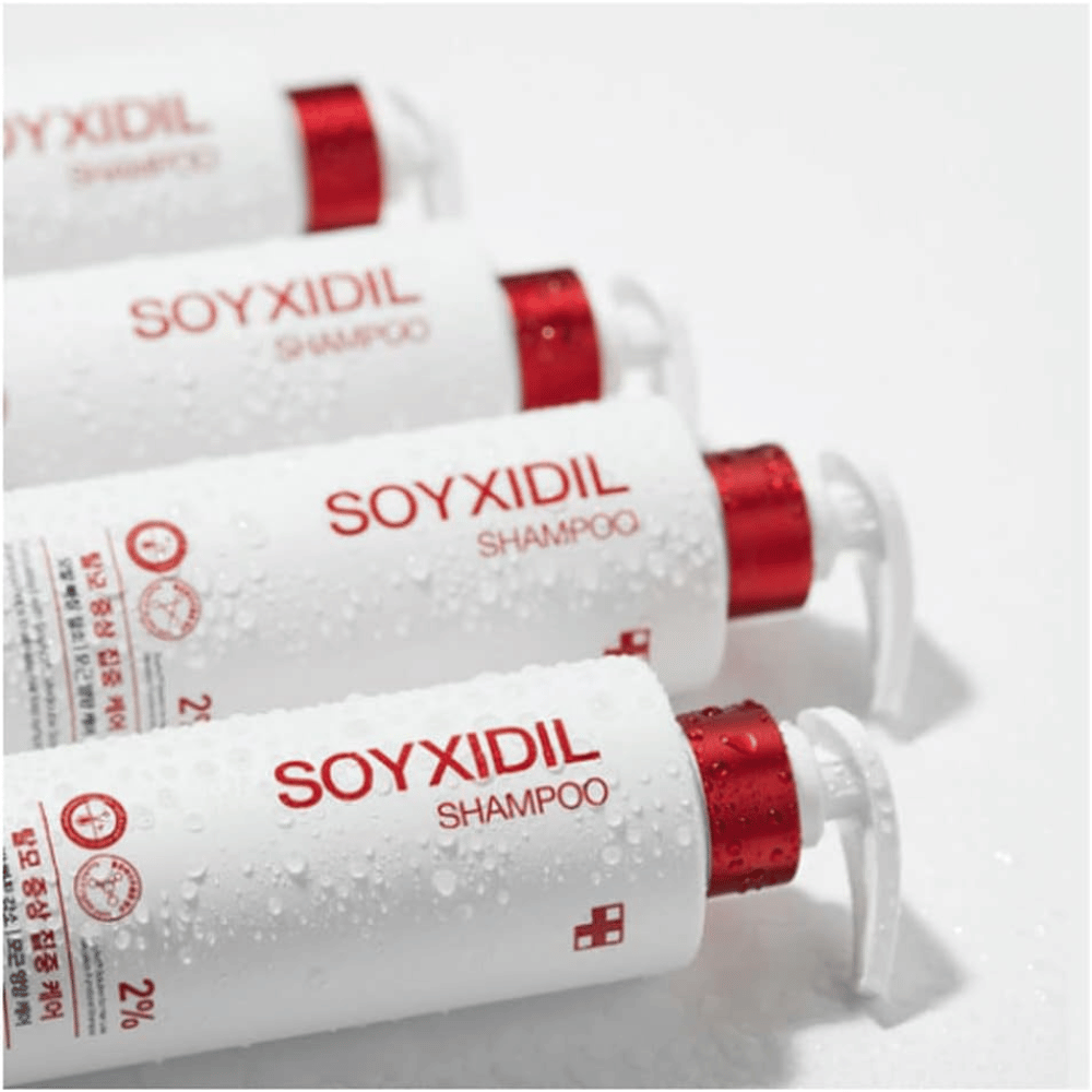 Flera flaskor av Medicube Soyxidil Shampoo ligger på rad med vattendroppar – visar produktens fräscha och vårdande känsla.