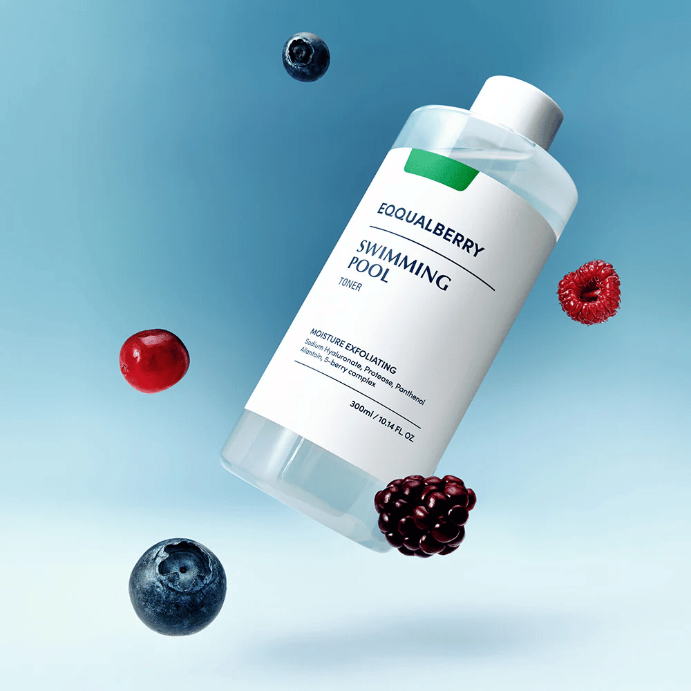 Equalberry Swimming Pool Toner i en stilren flaska svävande mot blå bakgrund, omgiven av färska bär som blåbär, hallon och björnbär.