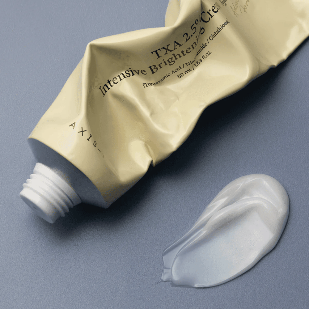 Produktbild med tuben och en klick kräm bredvid för att visa den mjuka, krämiga konsistensen och återfuktande formulan. Fokus ligger på glow och jämn applicering.