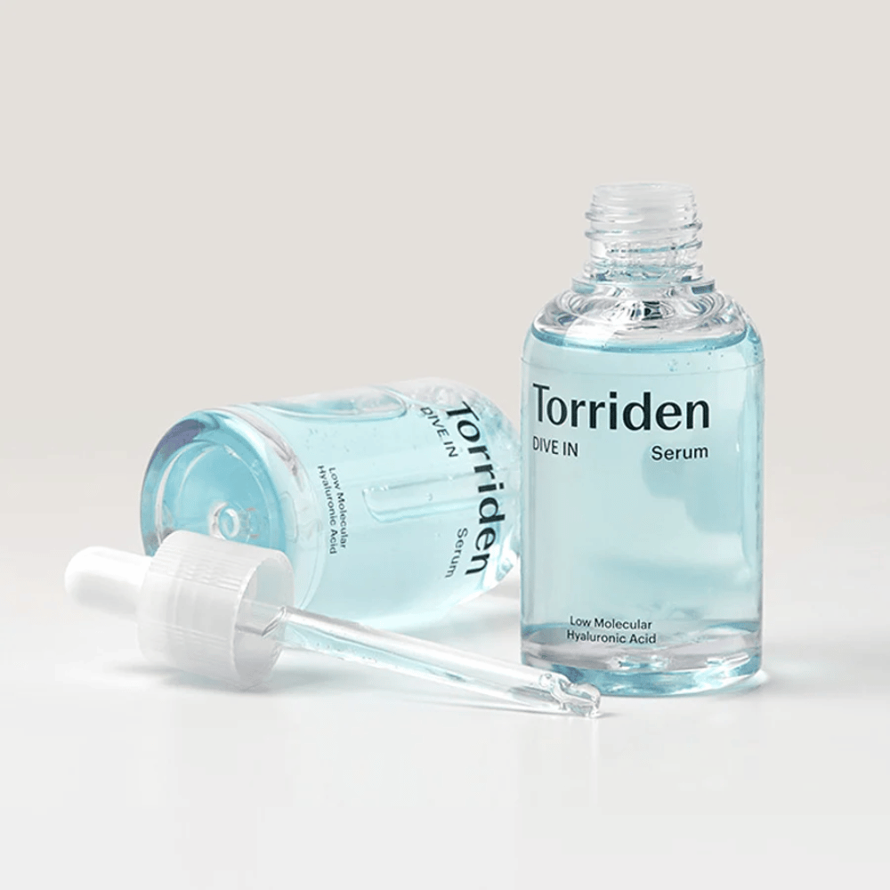 En flaska Torridens DIVE-IN Low Molecule Hyaluronic Acid Serum 50ml bredvid en flaska vatten, som betonar hyaluronsyraserum och återfuktning.