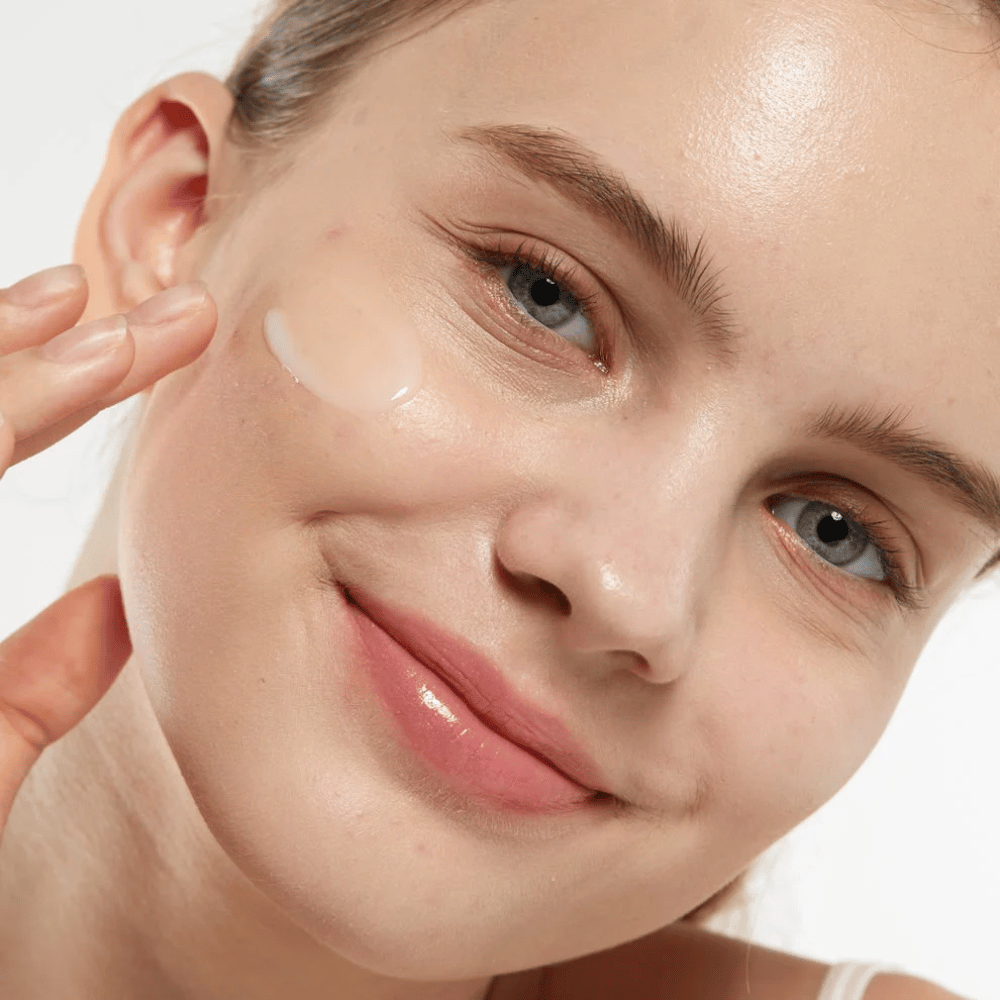 Modell som applicerar Medicube Zero Pore Serum 2.0 på kinden, ett porförfinande serum som ger jämnare hudstruktur, återfuktning och en naturlig lyster.