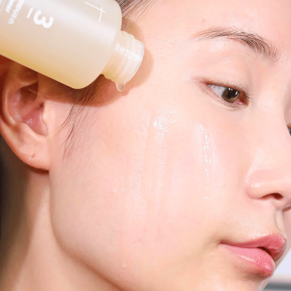 En kvinna använder No.3 Super Glowing Essence Toner 200ml av numbuzin i ansiktet för att upprätthålla en fuktbalans.
