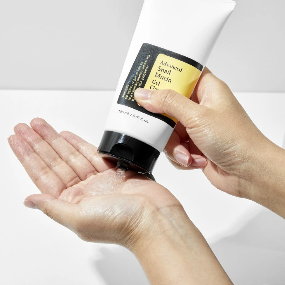 En person som håller i en tub COSRX Advanced Snail Mucin Gel Cleanser 150ml för känslig hud.