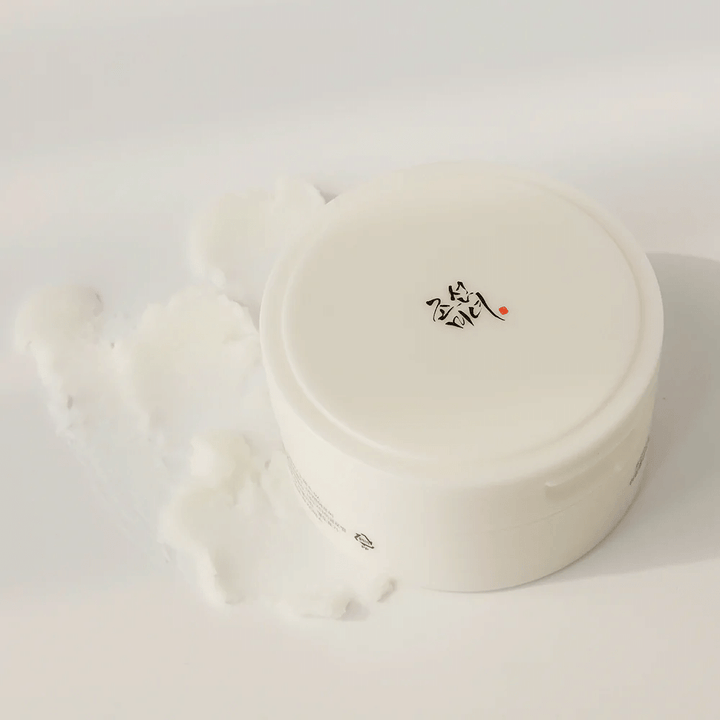 En vit behållare med vitt lock som innehåller Beauty of Joseon's Radiance Cleansing Balm 100ml, en uppgraderad formula som effektivt tar bort smink och orenheter.